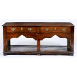 A George III oak dresser, the top with moulded lip above two plain drawers and arcaded apron, on