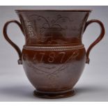 An English saltglazed brown stoneware loving cup, Derbyshire, dated 1787, with broad strap handles