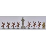 Seven Britains hollow cast figures of Scottish soldiers, a miniature cast brass figure of Rupert the