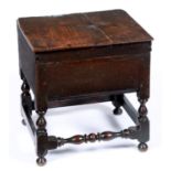 A joined oak close stool, 18th c, the boarded lid with iron butterfly hinges on baluster legs united