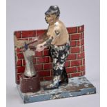 A mechanical lithographed  tinplate figural  blacksmith  at the anvil toy Working order, paint