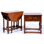 An oak side table, the leaf carved drawer with iron ring handle, on turned legs united by