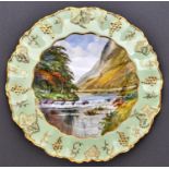 A Royal Crown Derby vine bordered plate, c1940, painted by W E J Dean, signed, with a view in