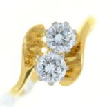 A diamond crossover ring,  with round brilliant cut diamonds, in 18ct gold, London 1988, 3g, size