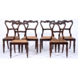 A set of six George IV carved rosewood dining chairs, on reeded tapering turned fore legs, caned