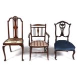 An Edwardian carved mahogany nursing chair, an Edwardian mahogany and inlaid side chair and a