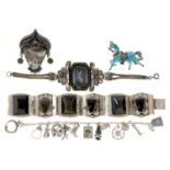 A silver charm bracelet, two others, one niello decorated, a brooch and silver and enamel horse