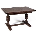 An oak draw leaf dining table, c1930,  on carved cup-and-cover end supports and sledge bases with