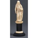 A French ivory statuette of a female saint, 19th c, an open breviary in her left hand, on ivory
