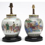 A pair of Chinese famille rose jars and covers, early 20th c, enamelled with continuous scenes,