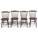 A set of four stained-beech stick back kitchen chairs, with round ash or beech seat, on turned legs,