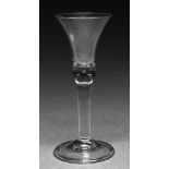 An English wine glass, mid 18th c, the bell bowl with solid base with tear, on plain stem, folded
