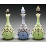 One and a pair of clear and red paste jewelled and frosted blue or green glass scent bottles and