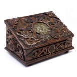 A Continental carved walnut box, the sloping lid set with an engraved brass clock dial with