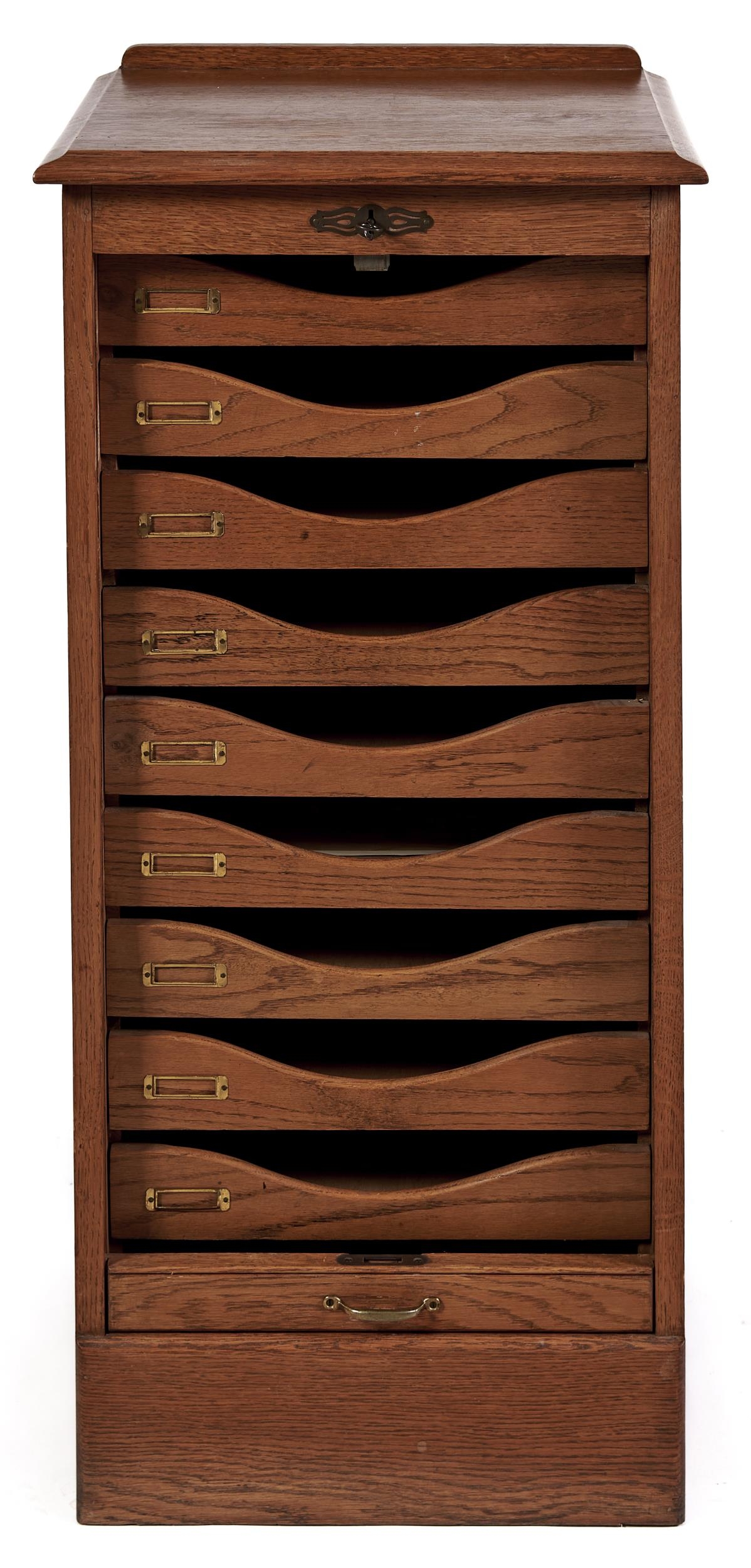 An oak filing cabinet, second quarter 20th c, fitted with trays enclosed by tambour shutter, the