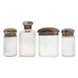 A glass bottle and three various jars with silver bun cap from a toilet set,  various sizes,