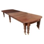 A substantial mahogany  dining table with rounded ends and three leaves, on six turned legs with