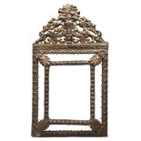 A stamped brass mirror, c1900, in 17th c Dutch style, the bevelled plate with shell clasps to the