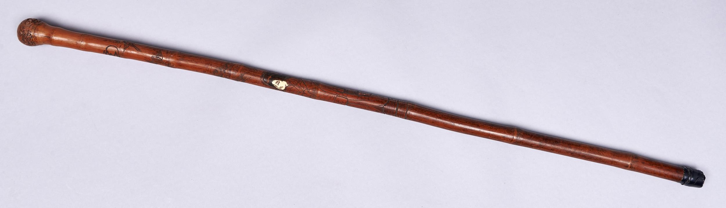 A Japanese bamboo and bone  cane, early 20th c, carved with a lady, cranes and landscape, 88cm l