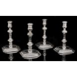 A set of four George I silver candlesticks, with banded sconce, the inverted baluster stem with