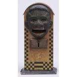 A German lithographed tinplate mechanical bank, c1930, the tongue shaped coin tray inscribed