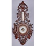 A German carved and stained wood aneroid barometer, c1900, with alcohol thermometer, applied with