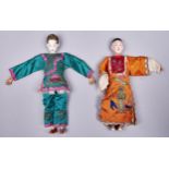 Two Chinese painted wood costume dolls, mid 20th c, in original embroidered silk clothes, 25cm h