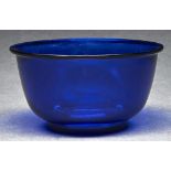 A Chinese blue glass bowl, the rounded sides beneath flange rim, on ring foot, 10.8cm diam Good