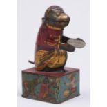 A lithographed tinplate mechanical frog bank, early 20th c, with gilt printed directions and Made in