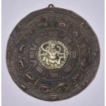 An Indian repousse sheet copper medallion or plaque, circumscribed with an inscription, 14cm diam