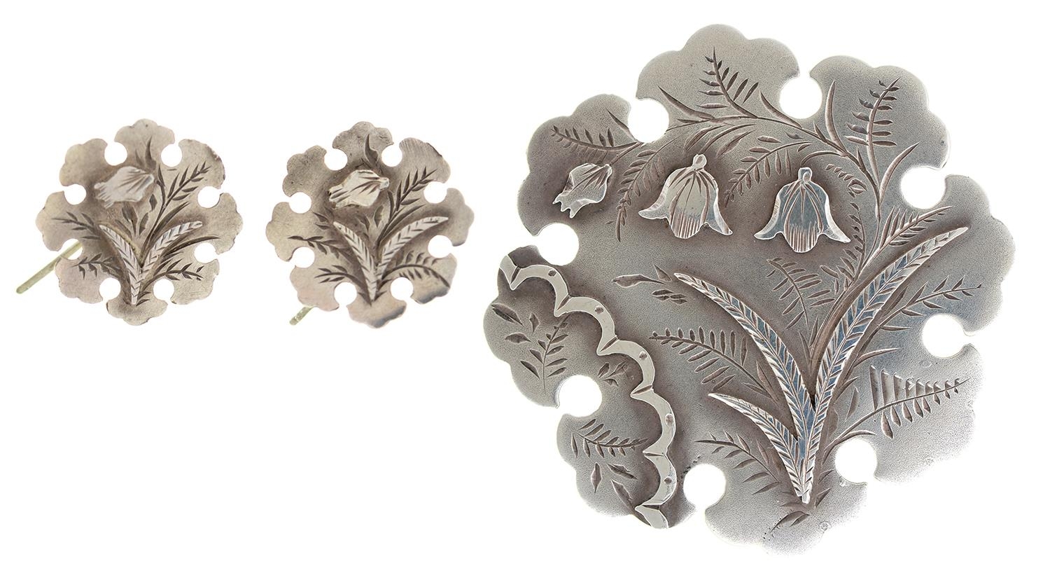 A Victorian silver brooch and pair of earrings en suite, with applied floral decoration, brooch