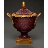 A French ormolu mounted porphyry urn and cover, 19th c, with overlapping acanthus leaf rim and