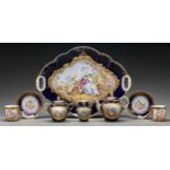 A French porcelain cabaret set, c1900, painted with 18th c scenes of rustic courtship in raised gilt