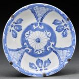 A Chinese blue and white dish, painted with a central flower and three leaves to each of three