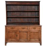 A George III oak dresser,  the boarded rack with cavetto cornice and scratch mouldings, the base