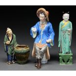 A Chinese porcelain figure of an immortal, in green, aubergine and yellow robe, on pierced base,