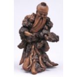 A Chinese wood and rootwood carving of an immortal, with glass eyes, 37cm h Minor losses and