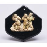 A Japanese ivory carving of four boys, Meiji period, 85mm h, on later affixed black painted wood