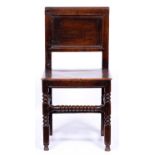 A mid 17th c oak chair, rectangular panelled back, boarded seat above bobbin and block turned legs