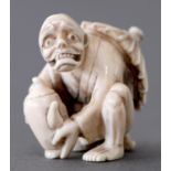 A Japanese ivory netsuke of a figure crouching beneath a parasol with a teapot, late 19th / early