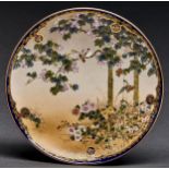 A Japanese Satsuma dish, Meiji period, finely painted with birds in a blossoming tree in cobalt