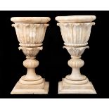A pair of Italian alabaster vases, c1840, carved with stiff leaves beneath moulded border, on