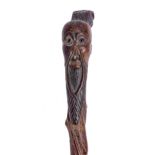 A Japanese carved wood cane, early 20th c, with the elongated head of a bearded man with glass eyes,