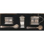 A George V three piece pierced silver condiment set, blue glass liners, pepperette 45mm, by Lanson