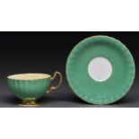 An Aynsley green ground teacup and saucer, mid 20th c, printed and painted after J A Bailey, printed