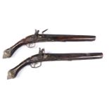 A pair of North Indian full stocked flintlock pistols, chased brass mounts and mother of pearl