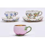 Two graduated Meissen floral encrusted cabinet cups and saucers, c1900, with entwined handle,