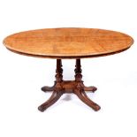 A Victorian walnut loo table, the figured oval top in matched veneers, on four fluted pillars each