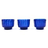 A set of three English spirally fluted blue glass finger bowls, early 19th c, sharp pontil scar,