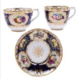 A Staffordshire cobalt ground bone china trio, probably Minton, c1830, painted with panels of fruit,